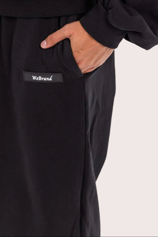 Black pants with a visible brand logo on a light gray background