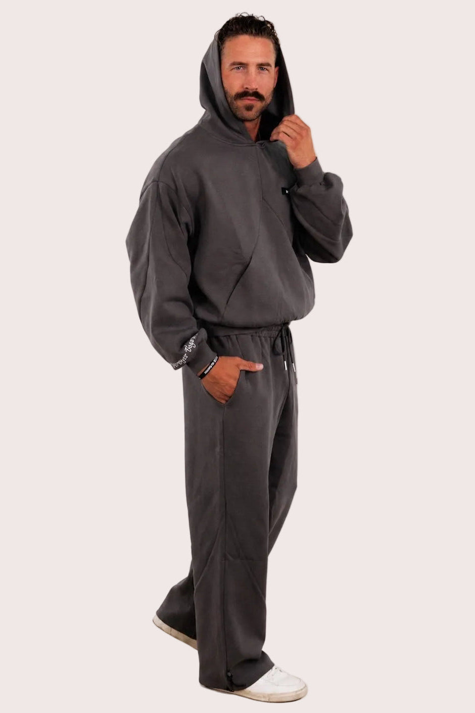 Man wearing a gray tracksuit against a plain background