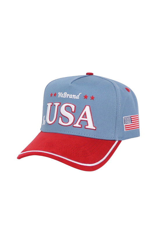 A patriotic baseball cap featuring a light blue crown with 'WeBrand USA' embroidered in red and white on the front, and a red brim with white piping and an American flag patch on the side.