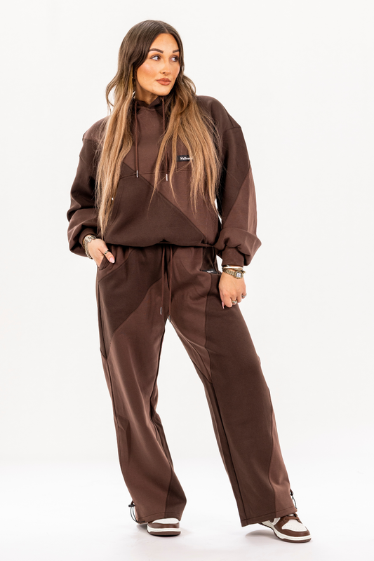 Person wearing a brown tracksuit on a white background