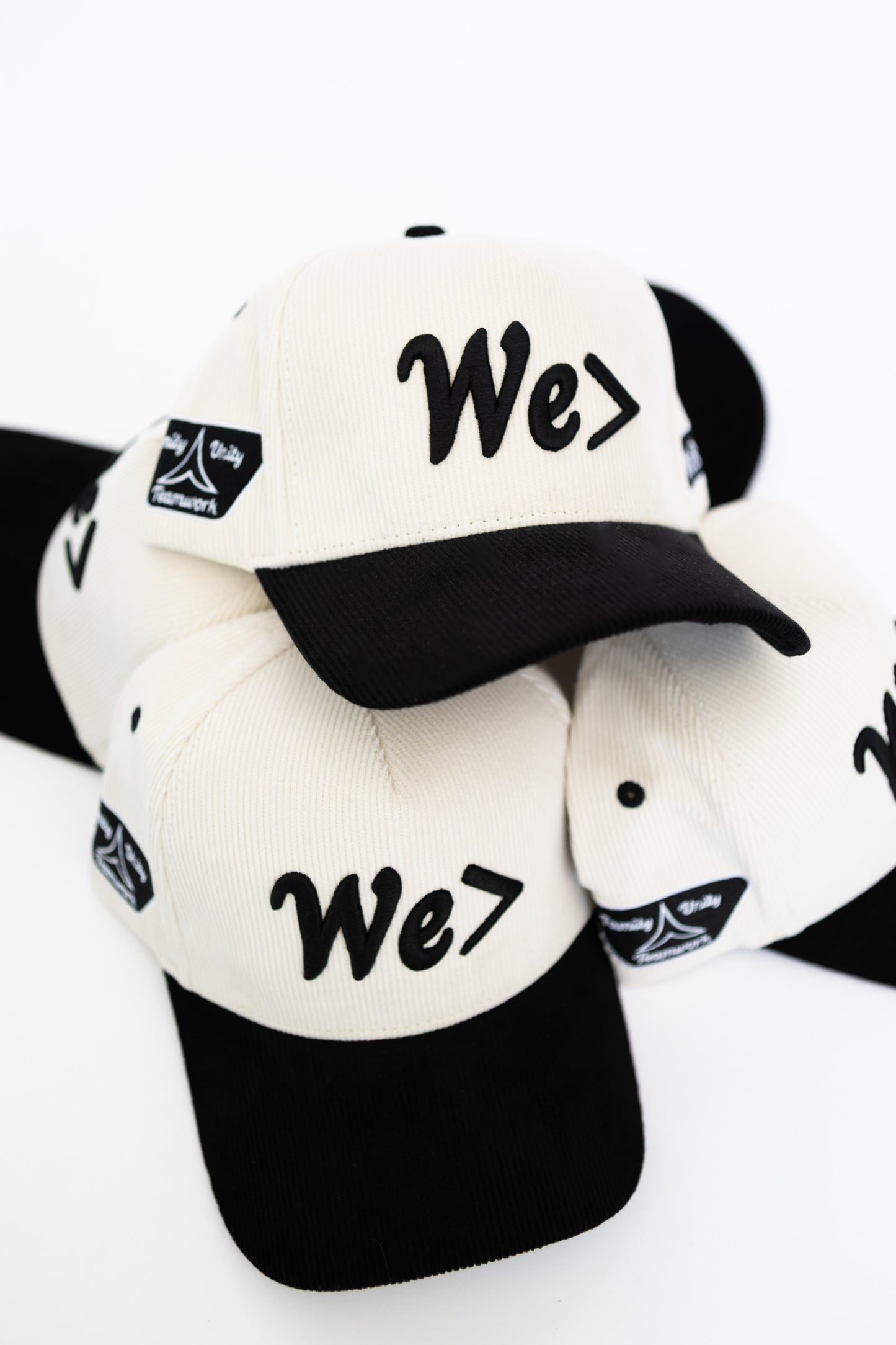 Black and white caps with 'We>' text on a white background