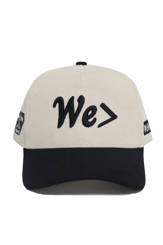 Beige and black cap with 'We>' text on a white background