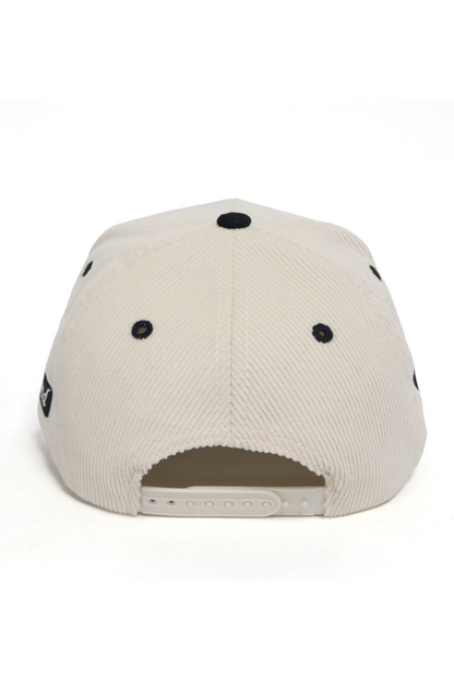 Back view of a beige cap with black accents on a white background