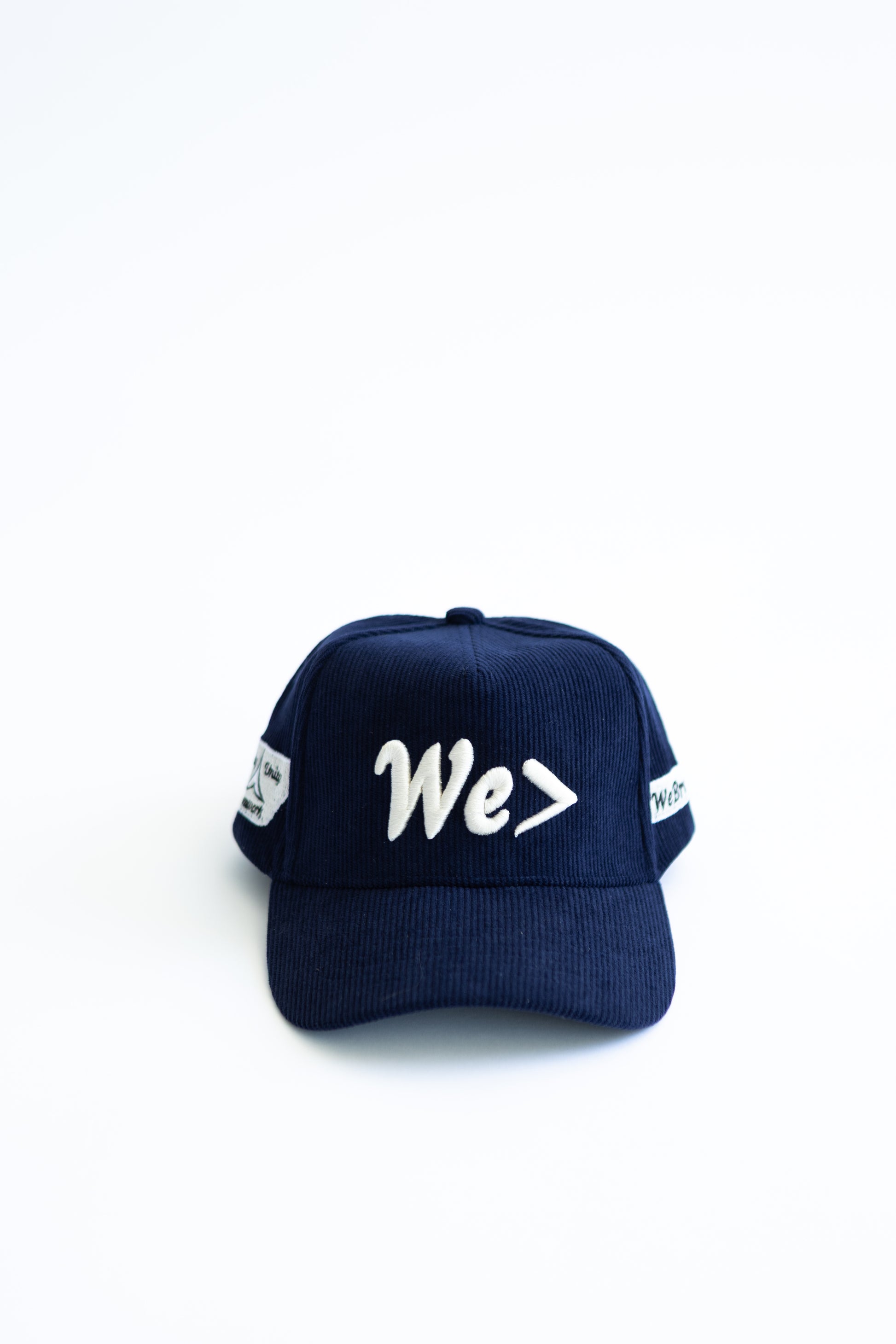 Navy blue cap with 'We>' text on a white background