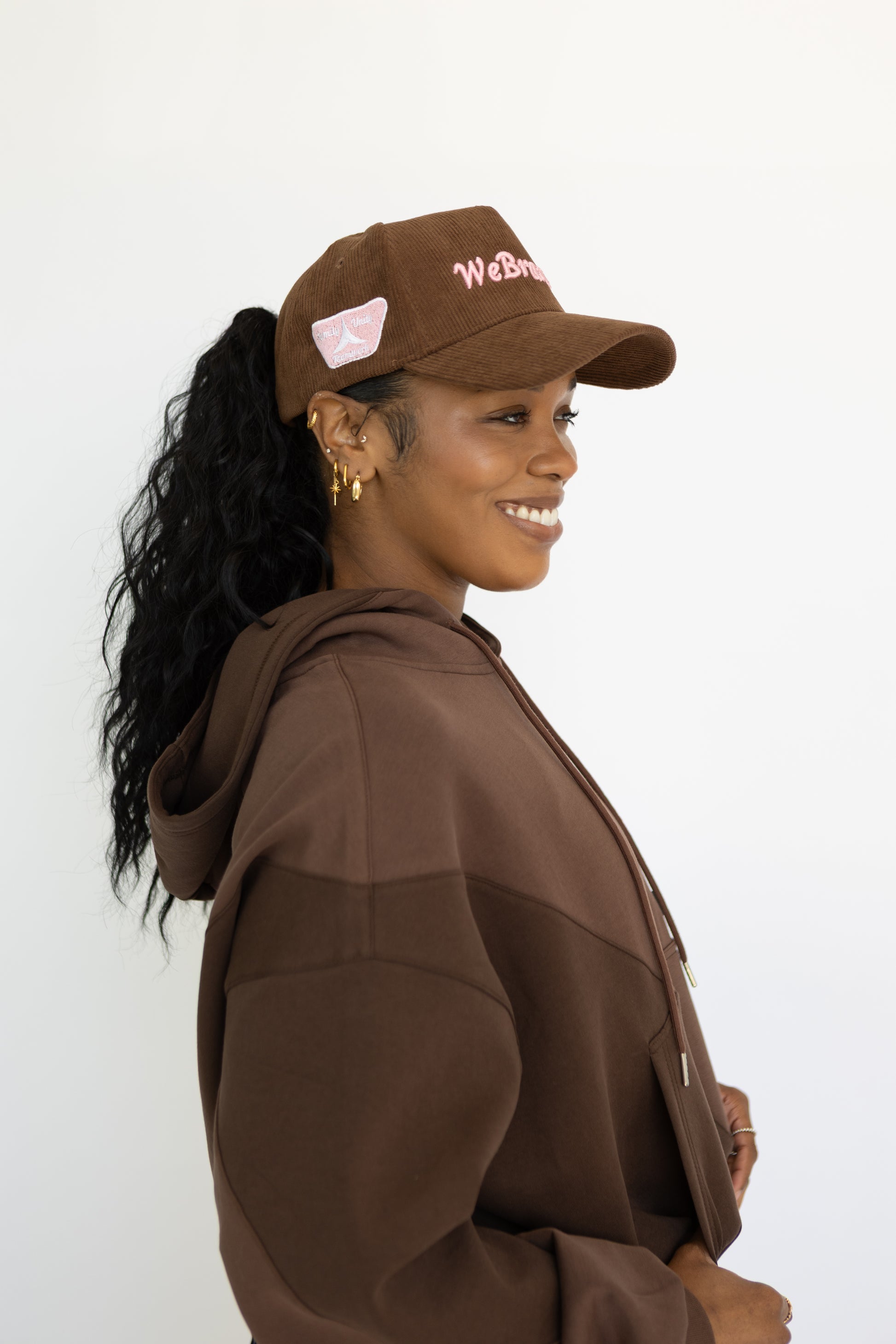 Woman wearing a brown cap and coat with a white background