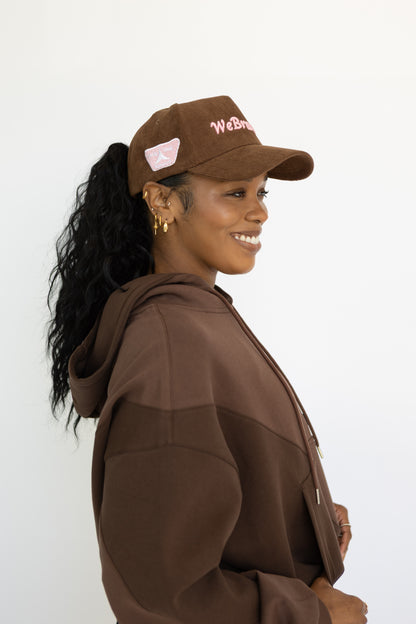 Woman wearing a brown cap and coat with a white background