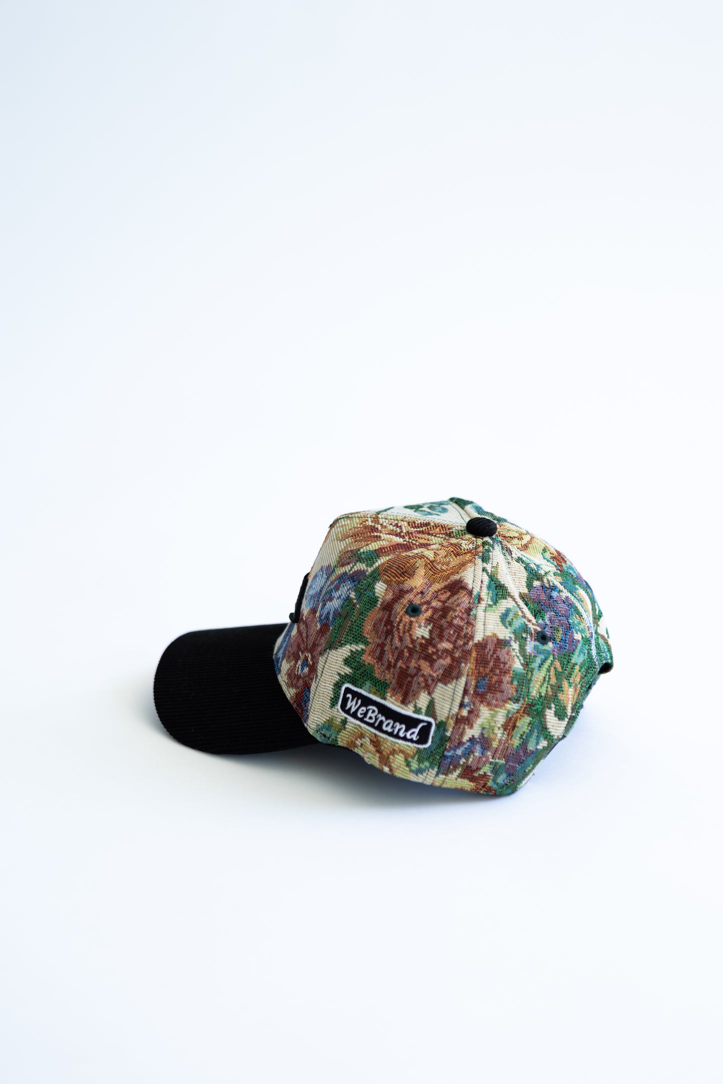 Floral-patterned cap with a brand logo on a white background