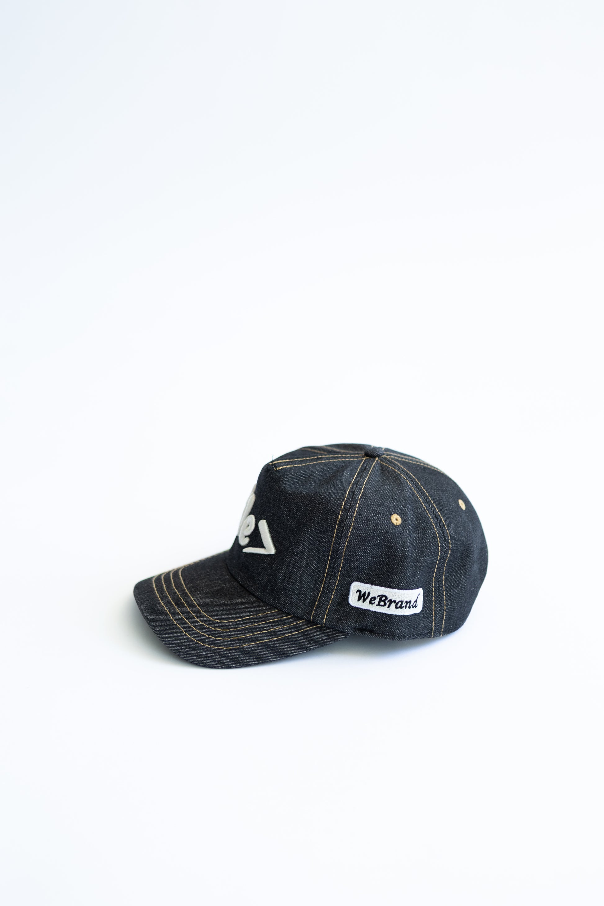 Dark denim cap with visible branding on a white background