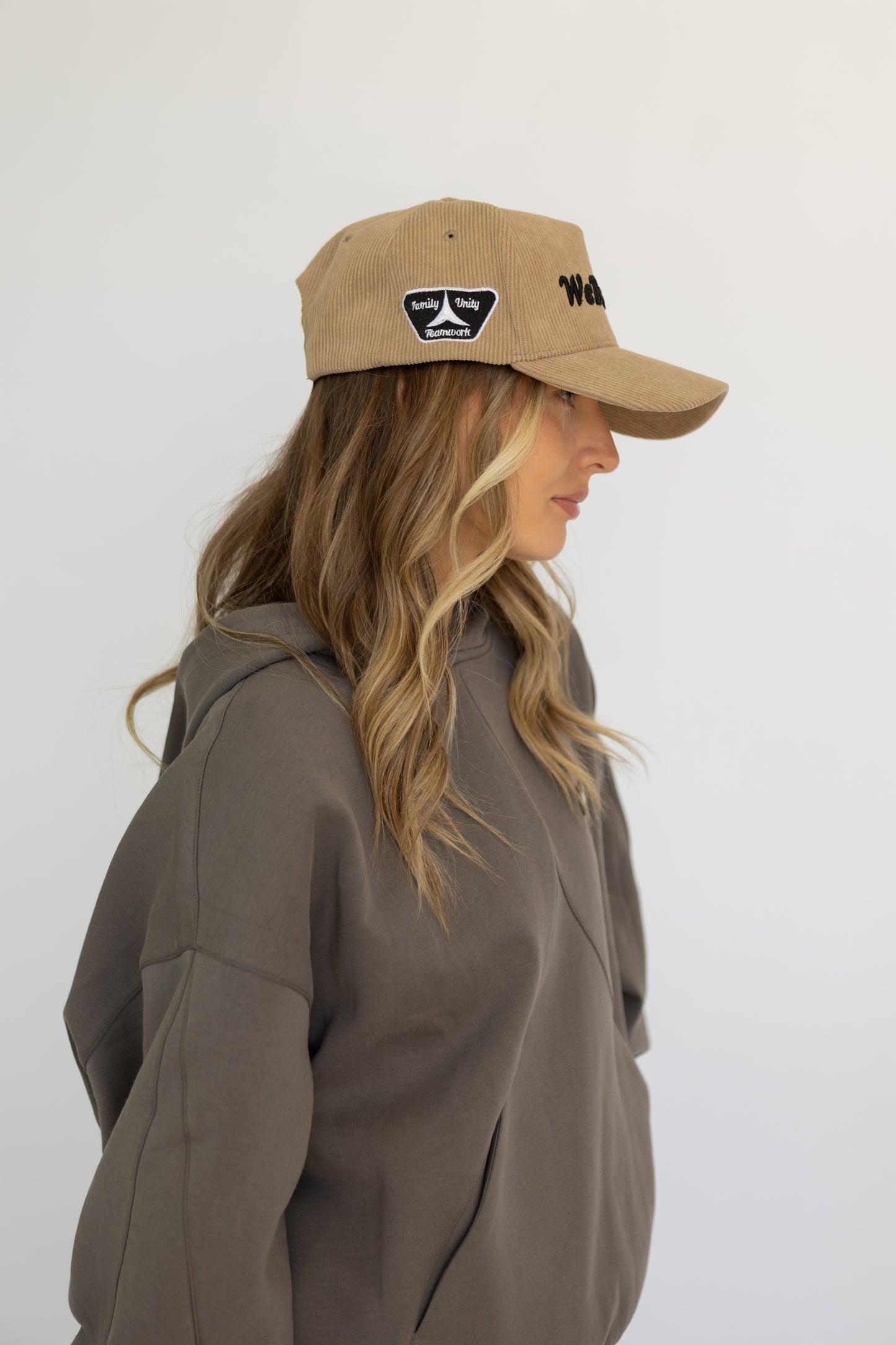 Woman wearing a brown cap and jacket against a white background