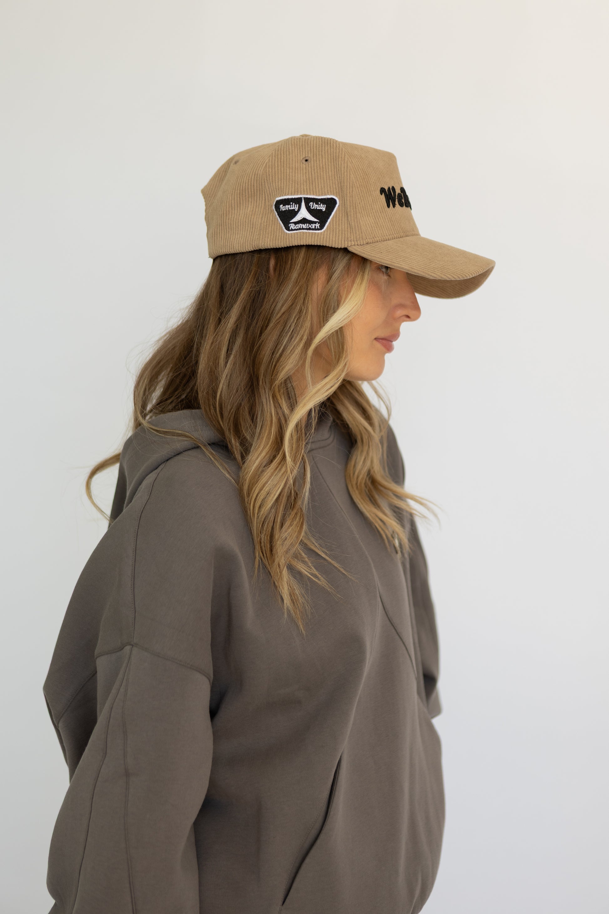 Woman wearing a brown cap and jacket against a white background