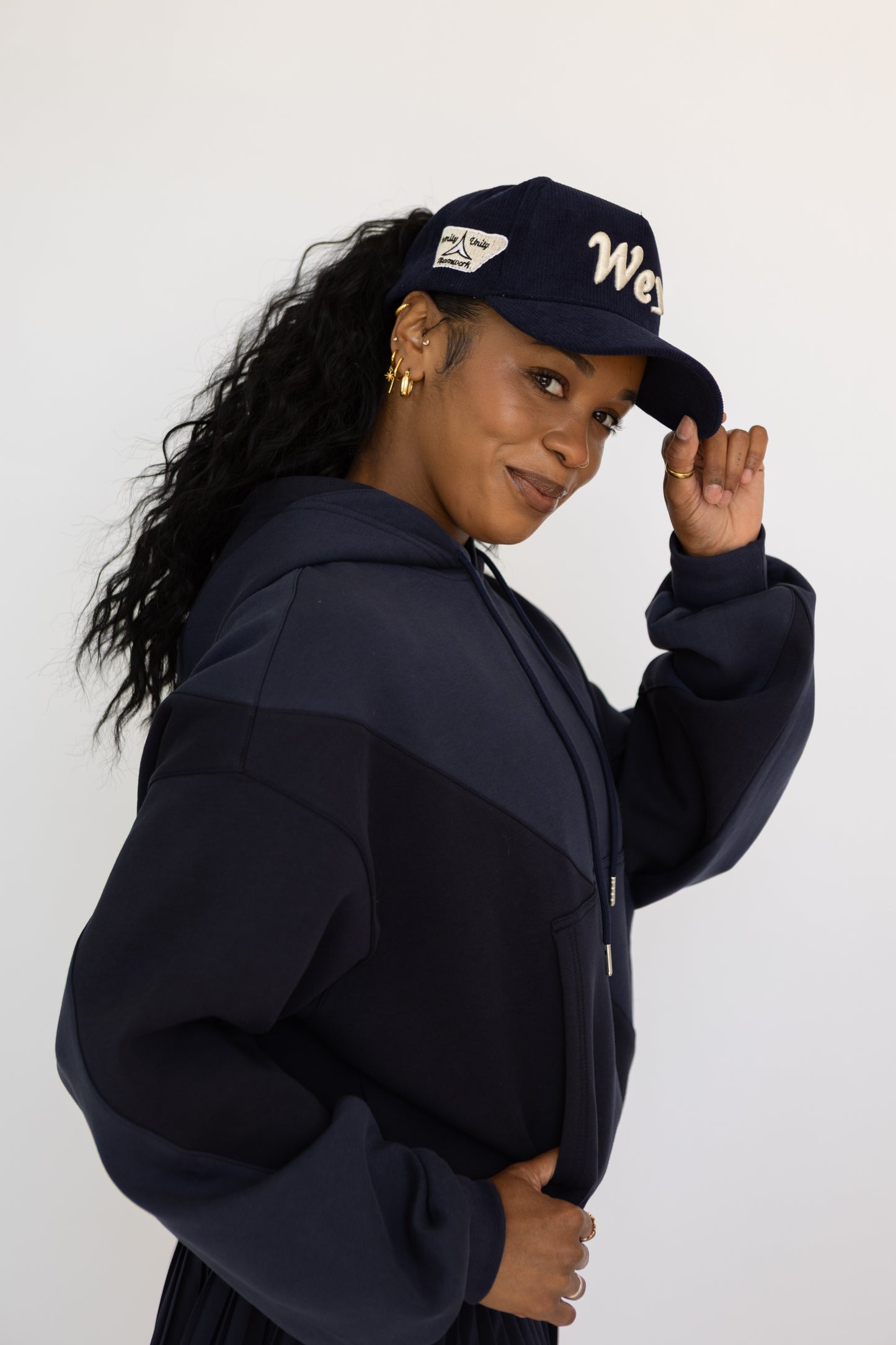 Woman wearing a navy blue cap and matching jacket against a white background