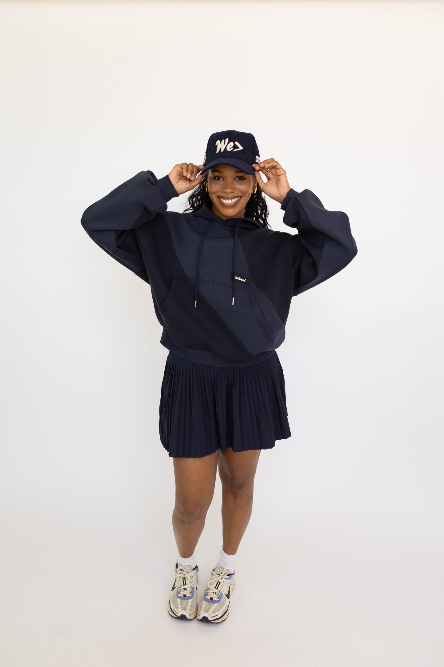 Person wearing a navy blue outfit with a matching cap on a white background