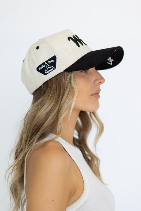 Woman wearing a two-tone cap with visible branding on a white background