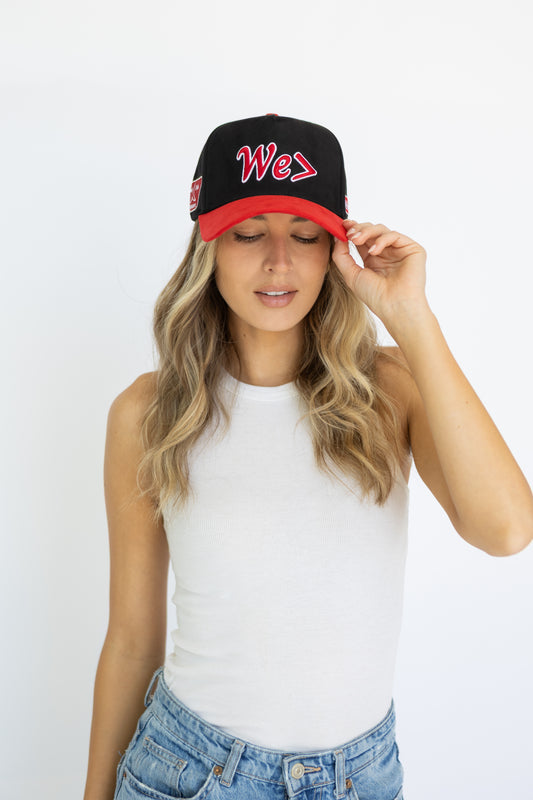 Woman wearing a black and red cap with 'We' text on a white background