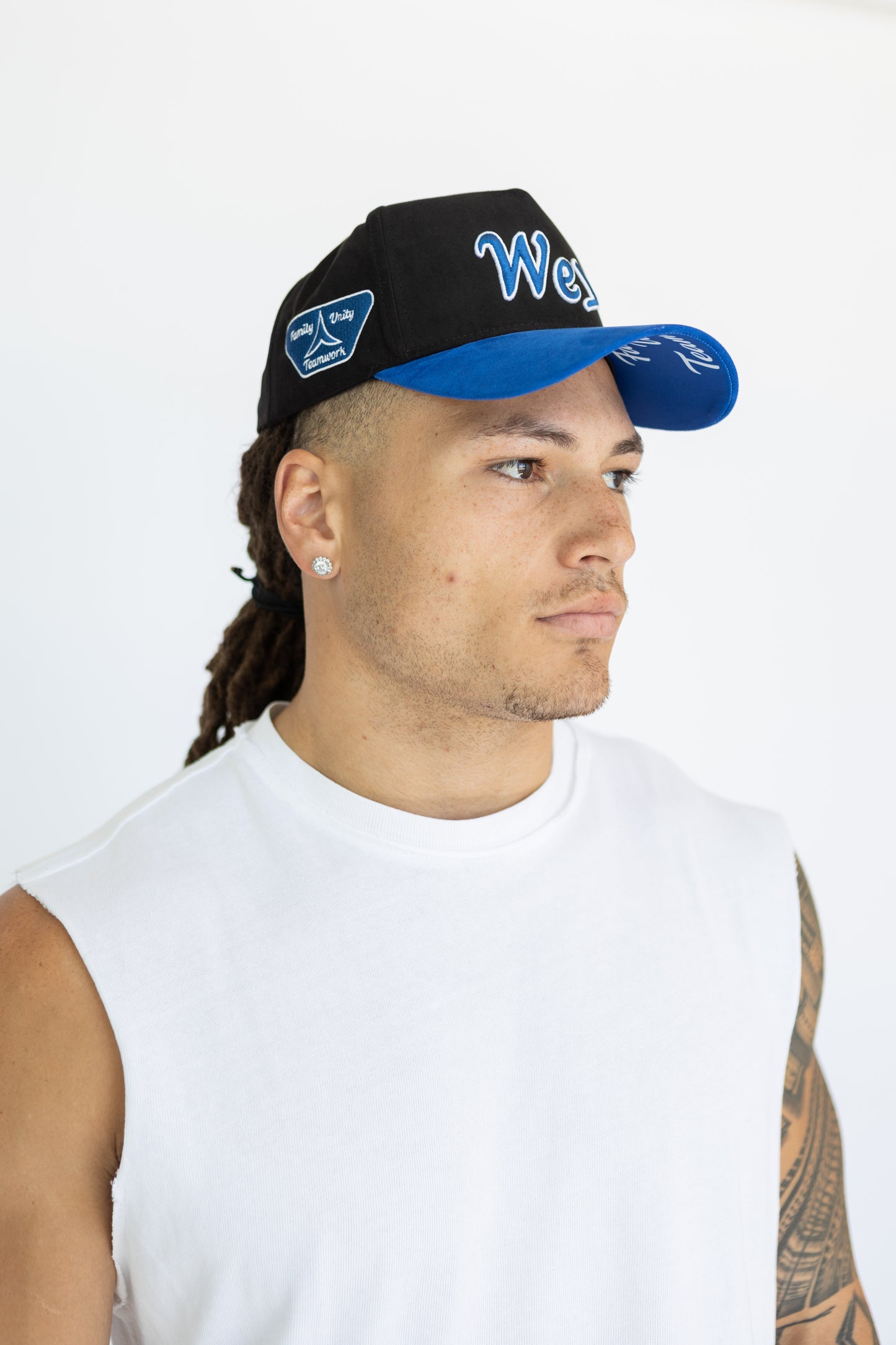 Man wearing a black and blue cap with visible branding on a white background