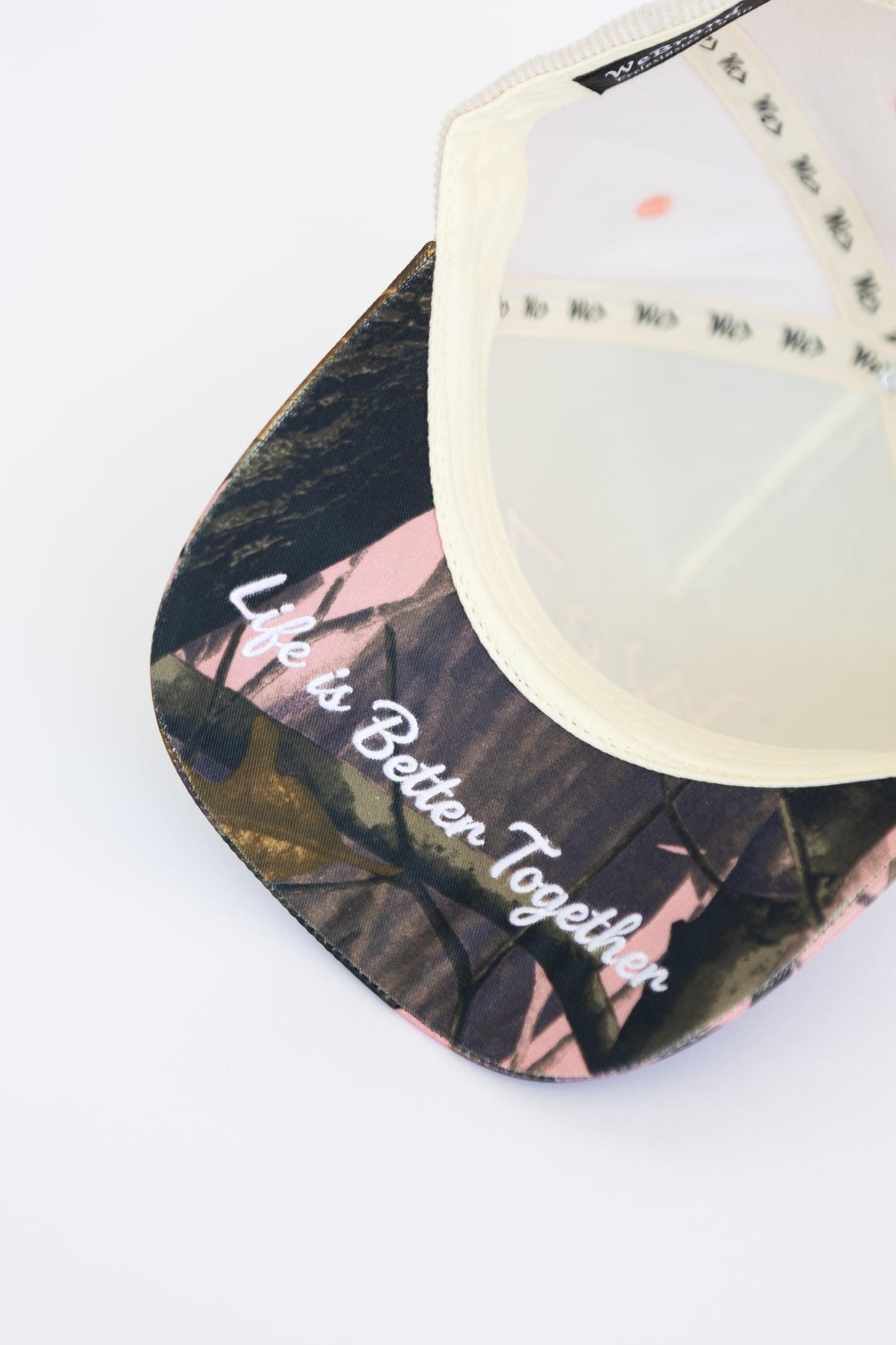 Cap with camo design and 'Life is Better Together' text on a white background