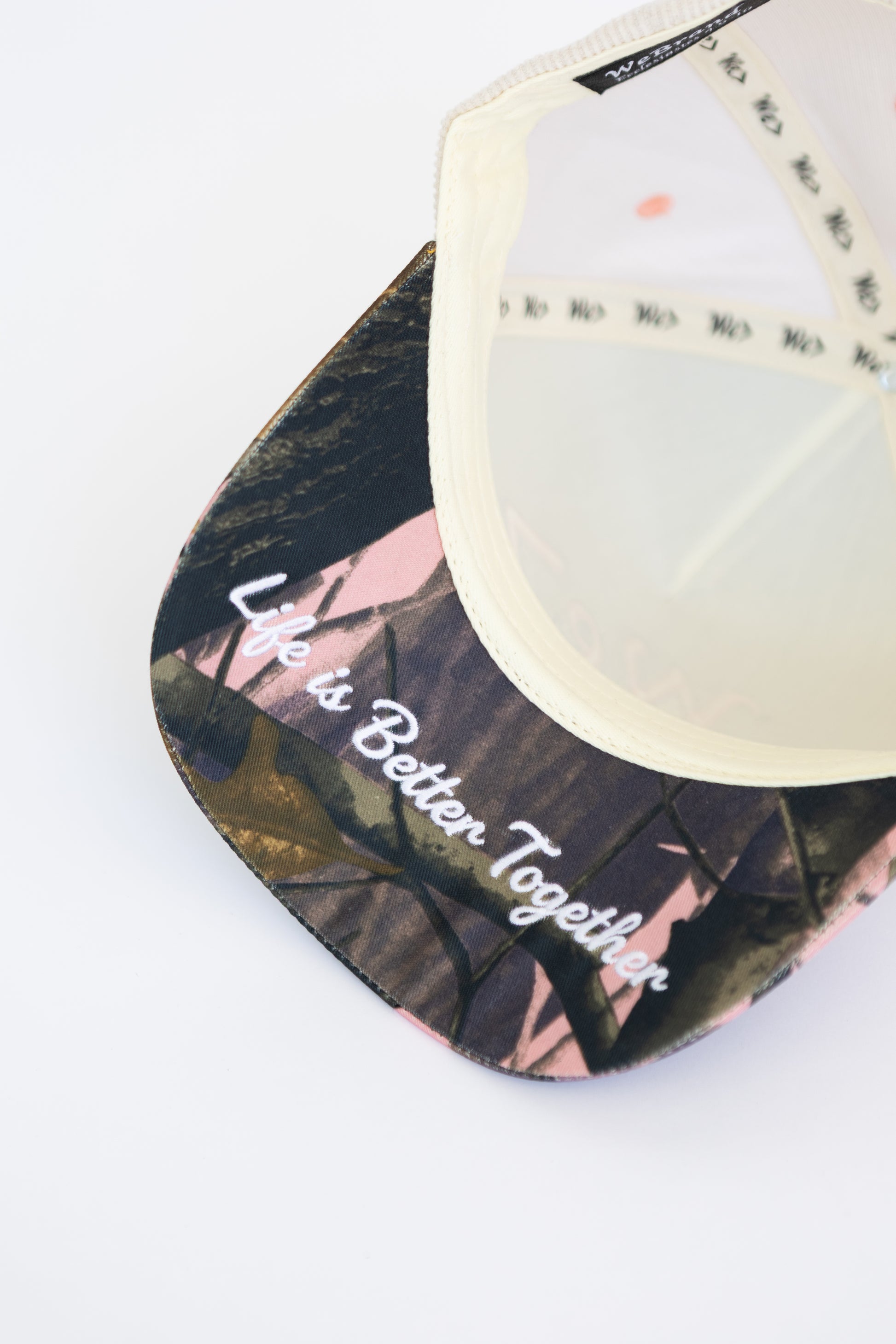 Cap with camo design and 'Life is Better Together' text on a white background