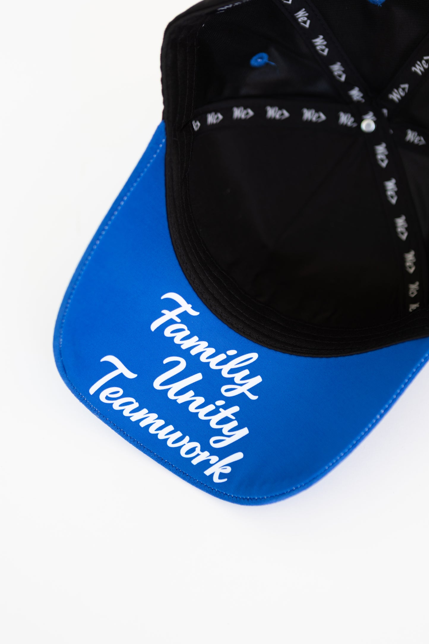 Black cap with white text that reads "Family Unity Teamwork" on a blue background