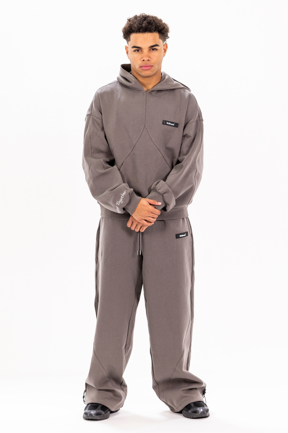 Man wearing a gray hoodie and pants set on a white background