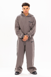Man wearing a gray hoodie and pants set on a white background