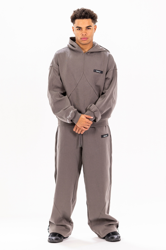 Man wearing a gray hoodie and pants set on a white background