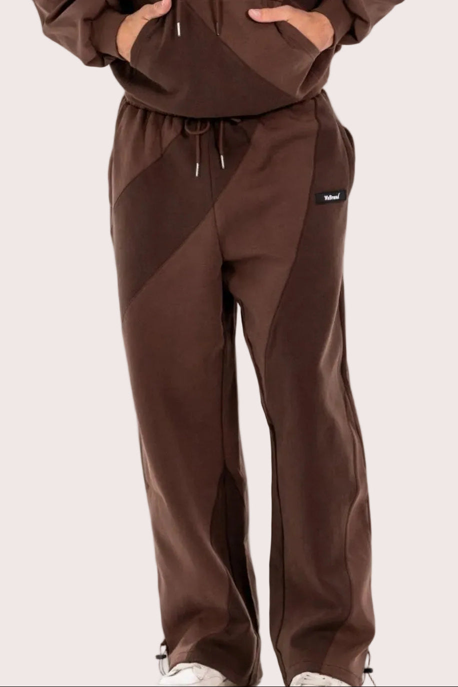 Man wearing a brown tracksuit on a white background
