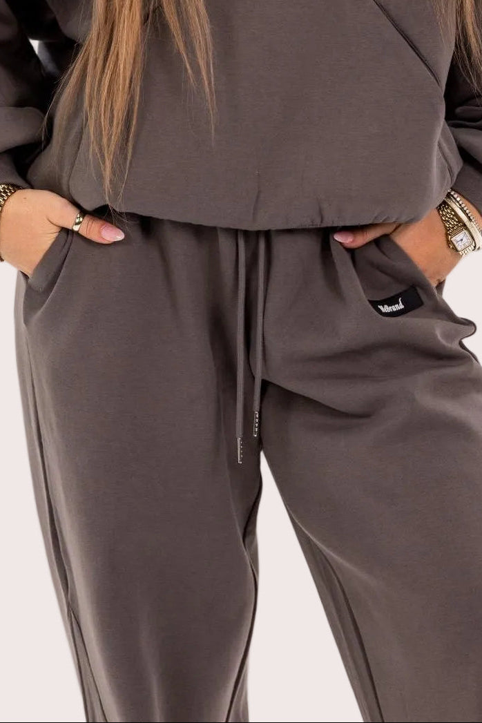 Person wearing a grey tracksuit on a plain background