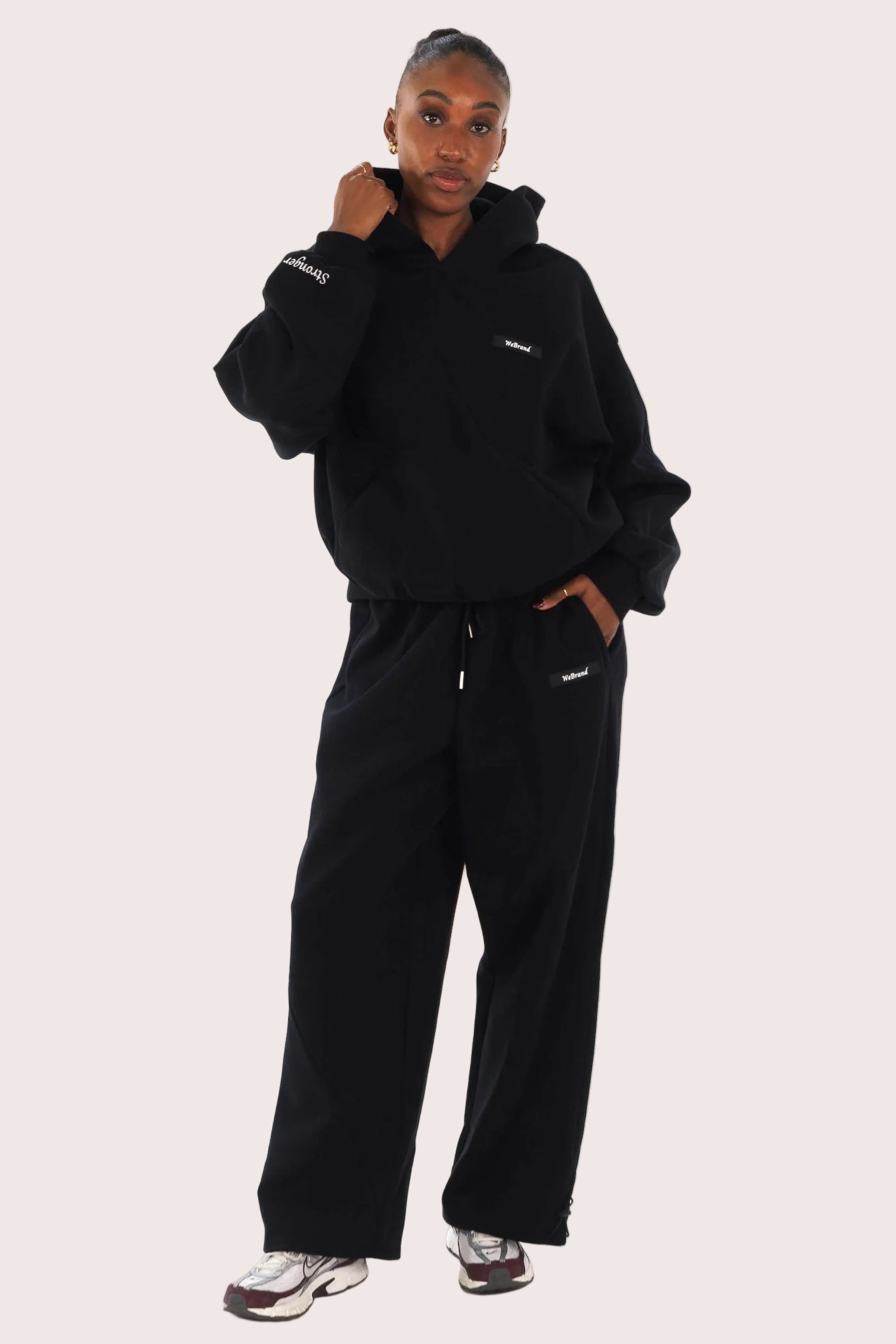 Person wearing a black tracksuit on a white background