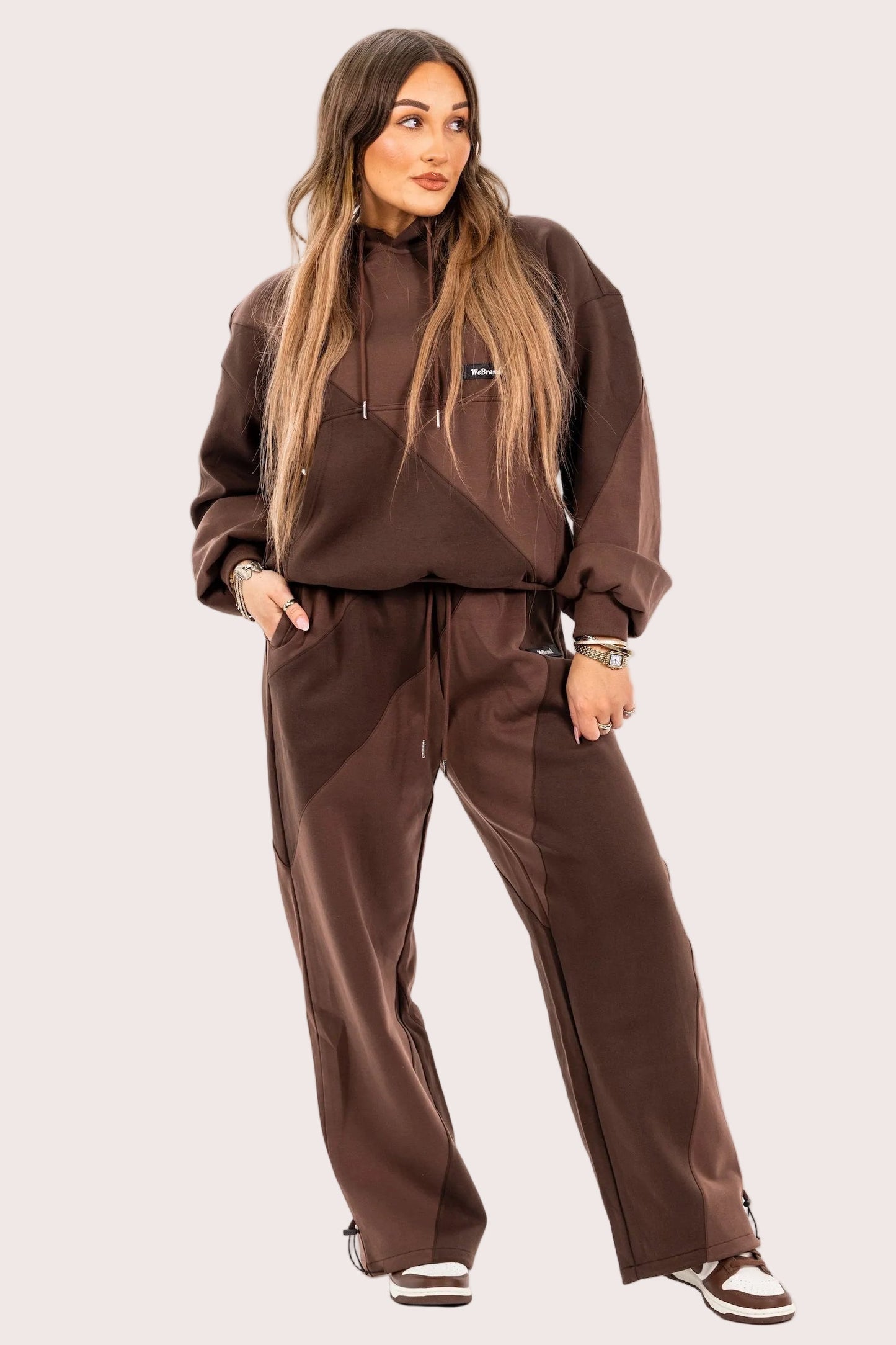 Woman wearing a brown tracksuit on a white background