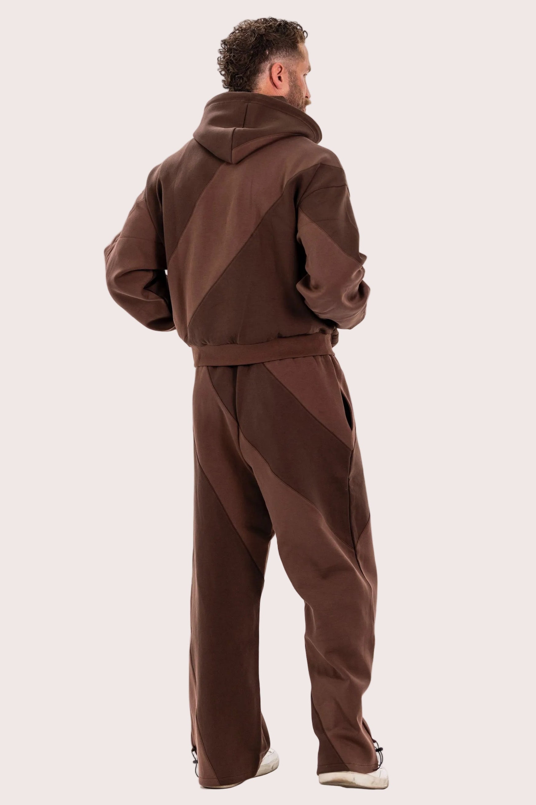 Man wearing a brown tracksuit on a white background