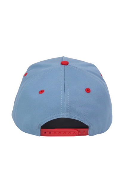 A light blue snapback cap shown from the back, featuring red button details and a red adjustable strap.