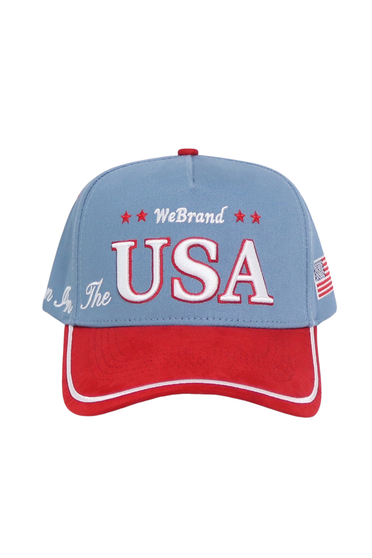 A patriotic baseball cap with a light blue crown and a red brim, featuring 'WeBrand USA' embroidered on the front, set against a plain white background.