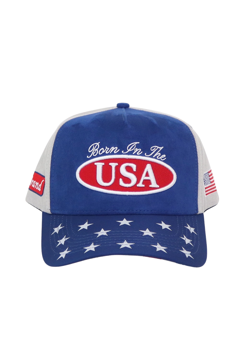 A patriotic trucker-style baseball cap with a royal blue front and brim, white mesh side panels, and a red oval patch reading 'USA' with the phrase 'Born In The' above it. The brim is decorated with white stars, and small American flag patches are visible on the side.