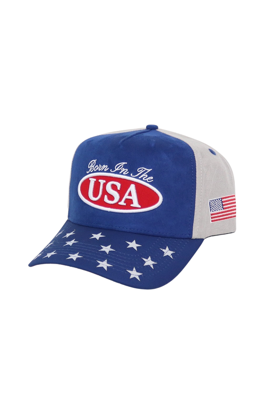 A patriotic baseball cap with a royal blue front and brim, light gray back panels, white embroidered stars on the brim, and a red, white, and blue oval USA logo on the front.
