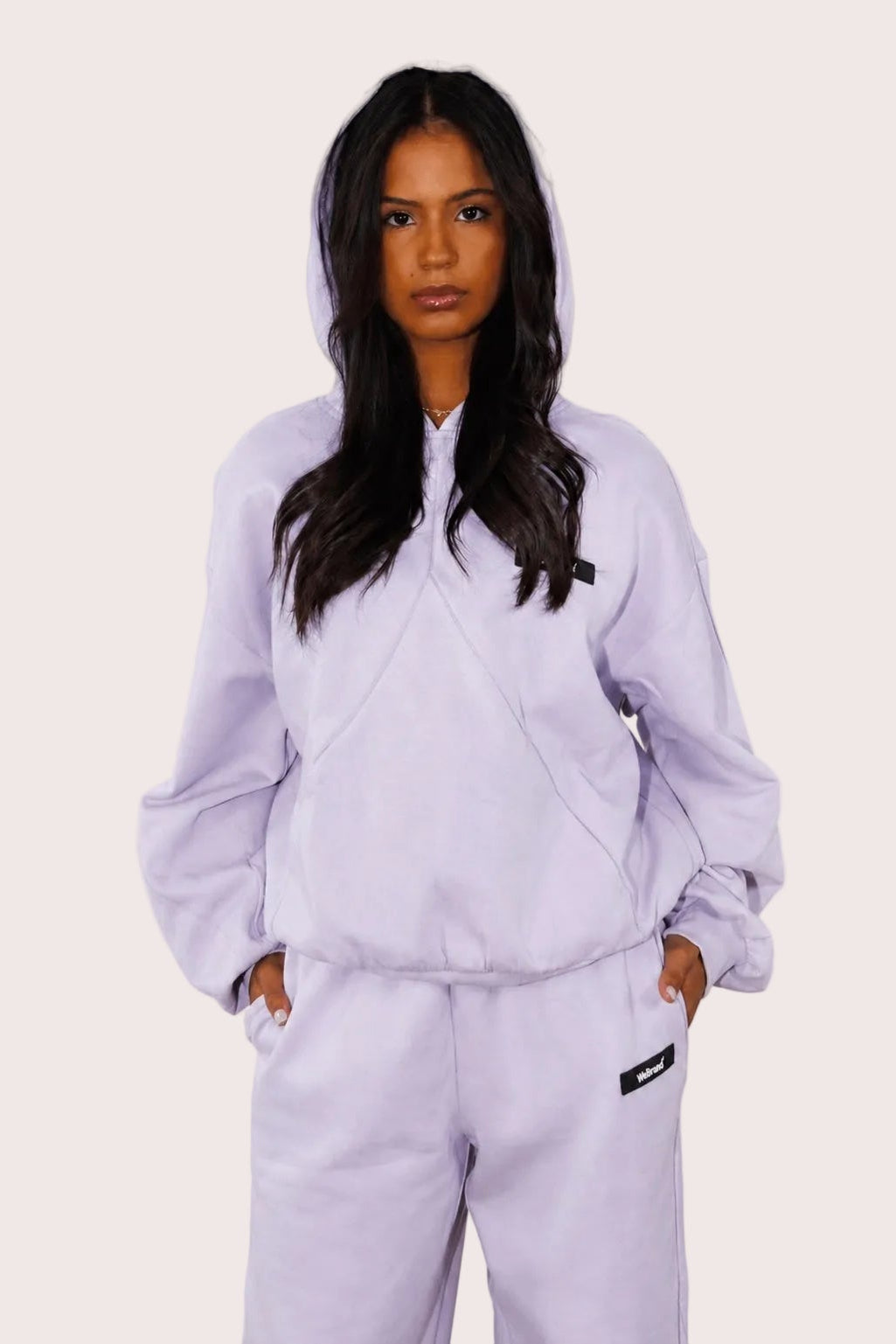 Person wearing a light purple tracksuit against a plain background