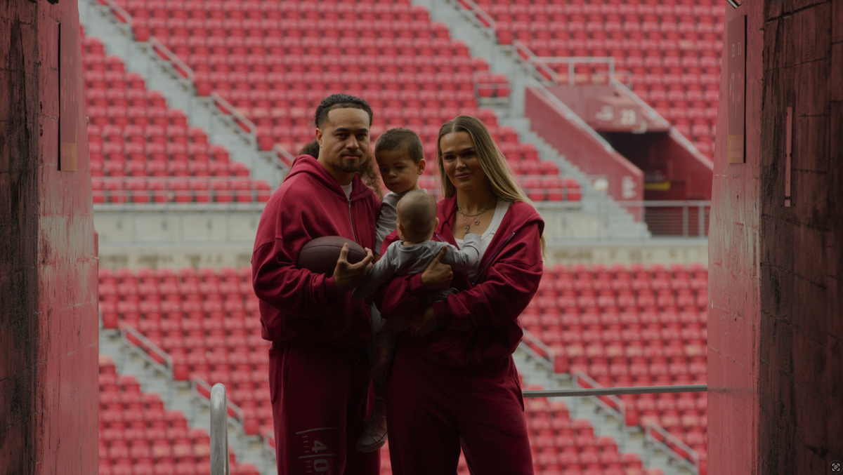Alyssa and Sione with their children in red sweats in the stadium tunnel